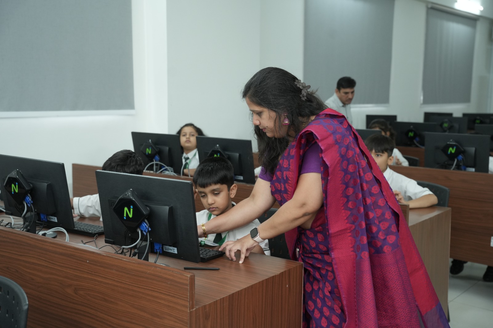 MIS teacher guiding a student in the computer lab
